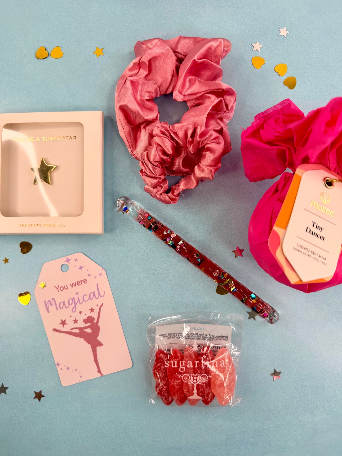 Collection of items including scrunchies, a pen, and a small box on a light blue background.