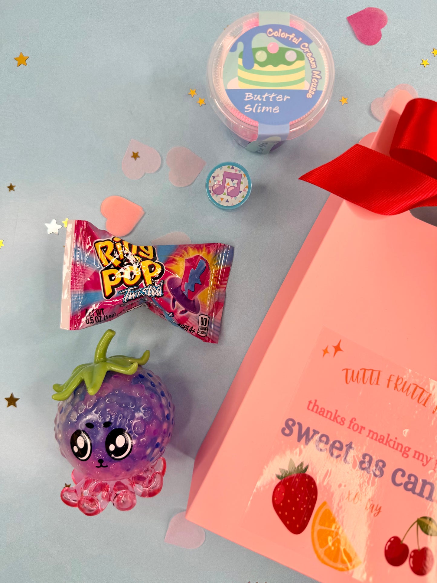 Assorted candy and a plush toy on a light blue background with decorative elements.