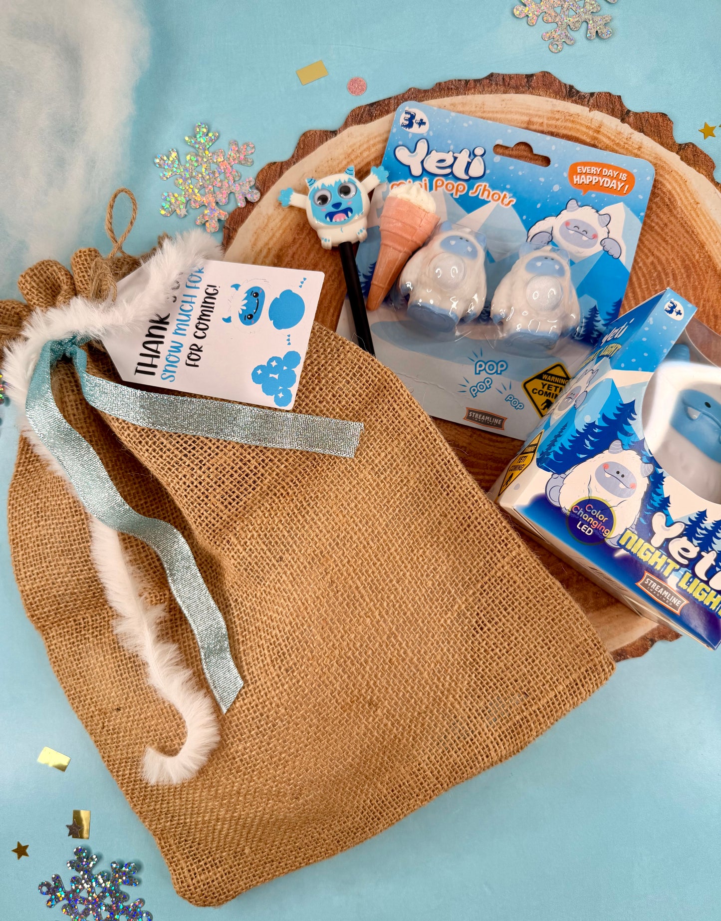 Pet care products including bags and packaging on a textured surface with decorative elements.