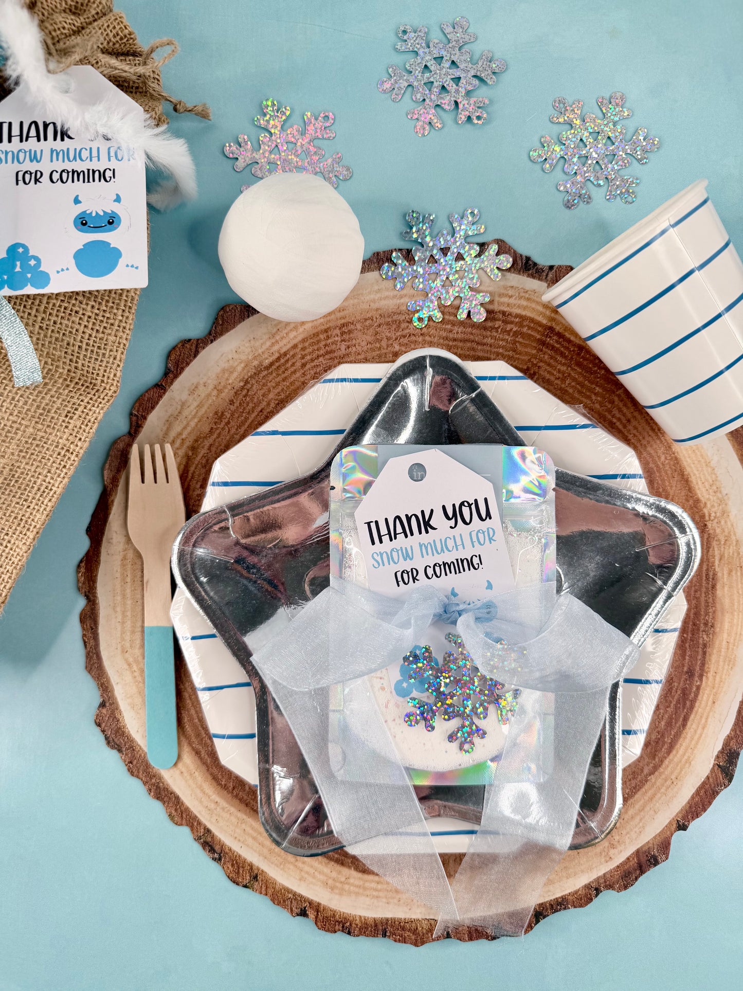 Placemat with cutlery, snowflake decorations, and 'Thank you' cards on a blue background