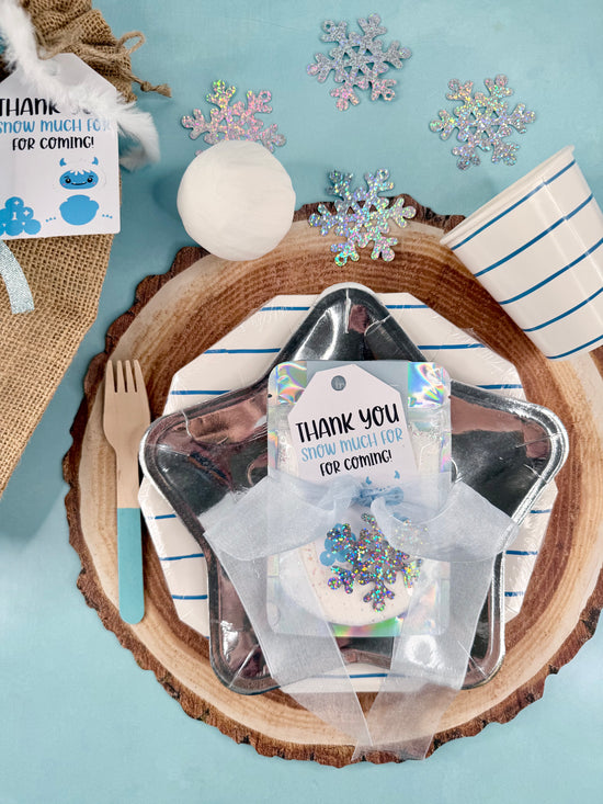 Placemat with cutlery, snowflake decorations, and 'Thank you' cards on a blue background