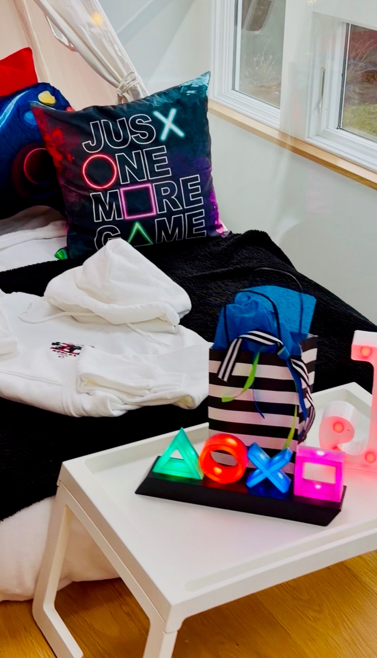 Room with gaming-themed decor including a pillow, controller, and neon lights.