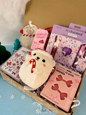 Assorted beauty products including a plush toy, makeup items, and stationery in a box.