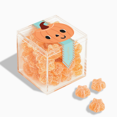 Clear cube container filled with orange gummy bears featuring a pumpkin design on the lid.