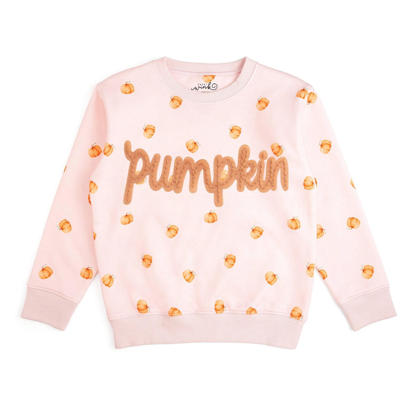 A light pink crewneck sweatshirt featuring the word 'pumpkin' in textured orange letters across the chest, surrounded by small orange pumpkin prints, laid flat on a white background.