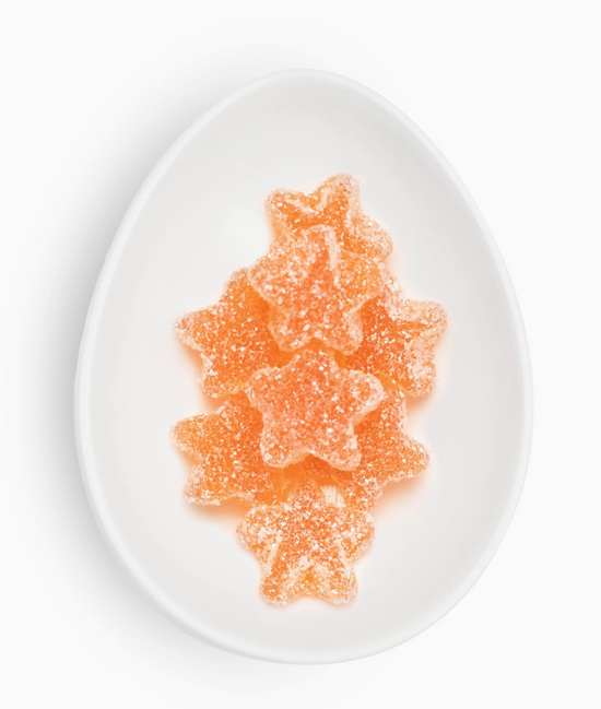 Star-shaped orange gummy candies on a white plate
