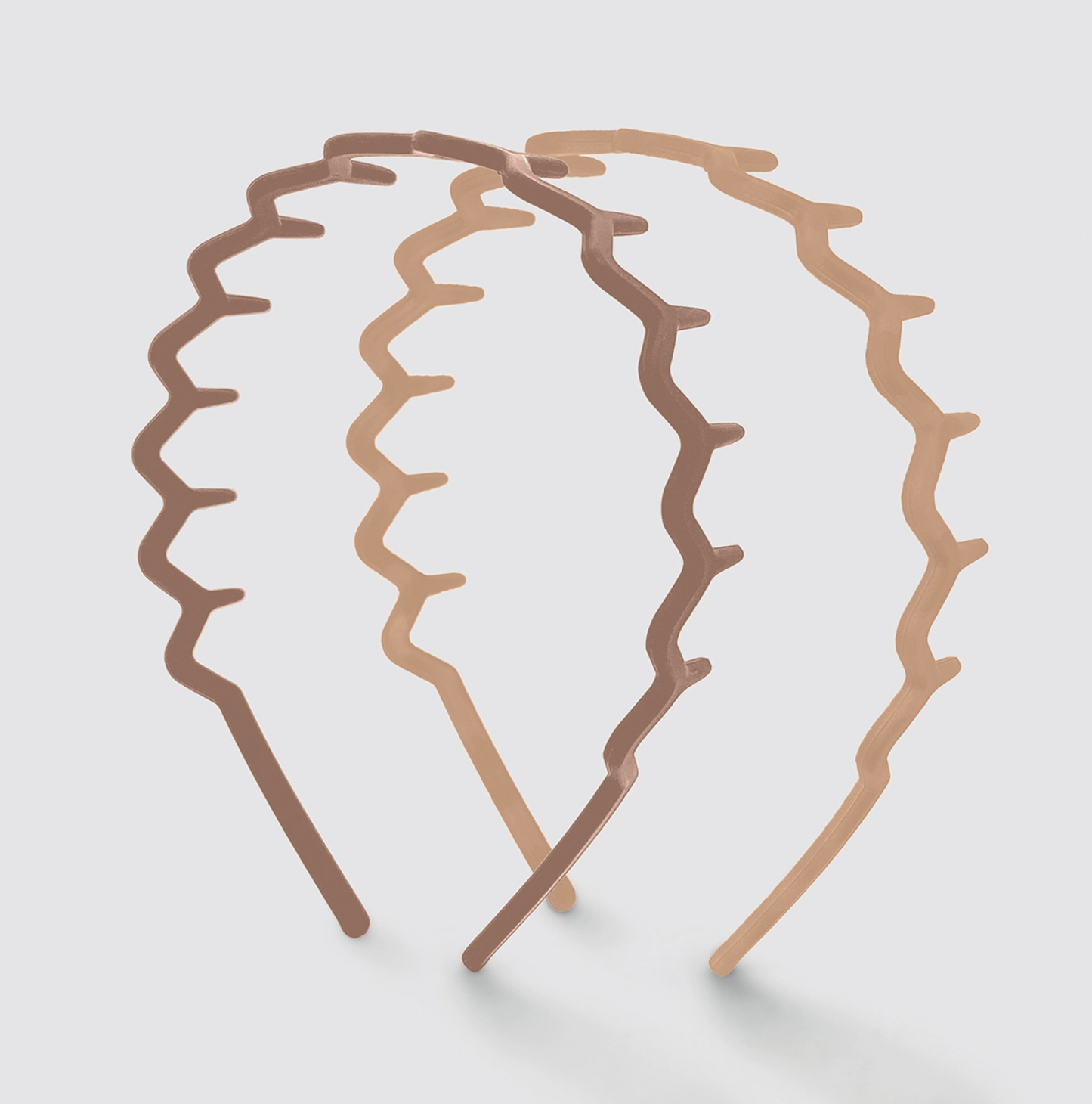 Three brown hair clips with wavy design on a light gray background