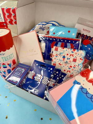 Assorted patriotic-themed items including cards, brooches, and other decorative pieces in a box.