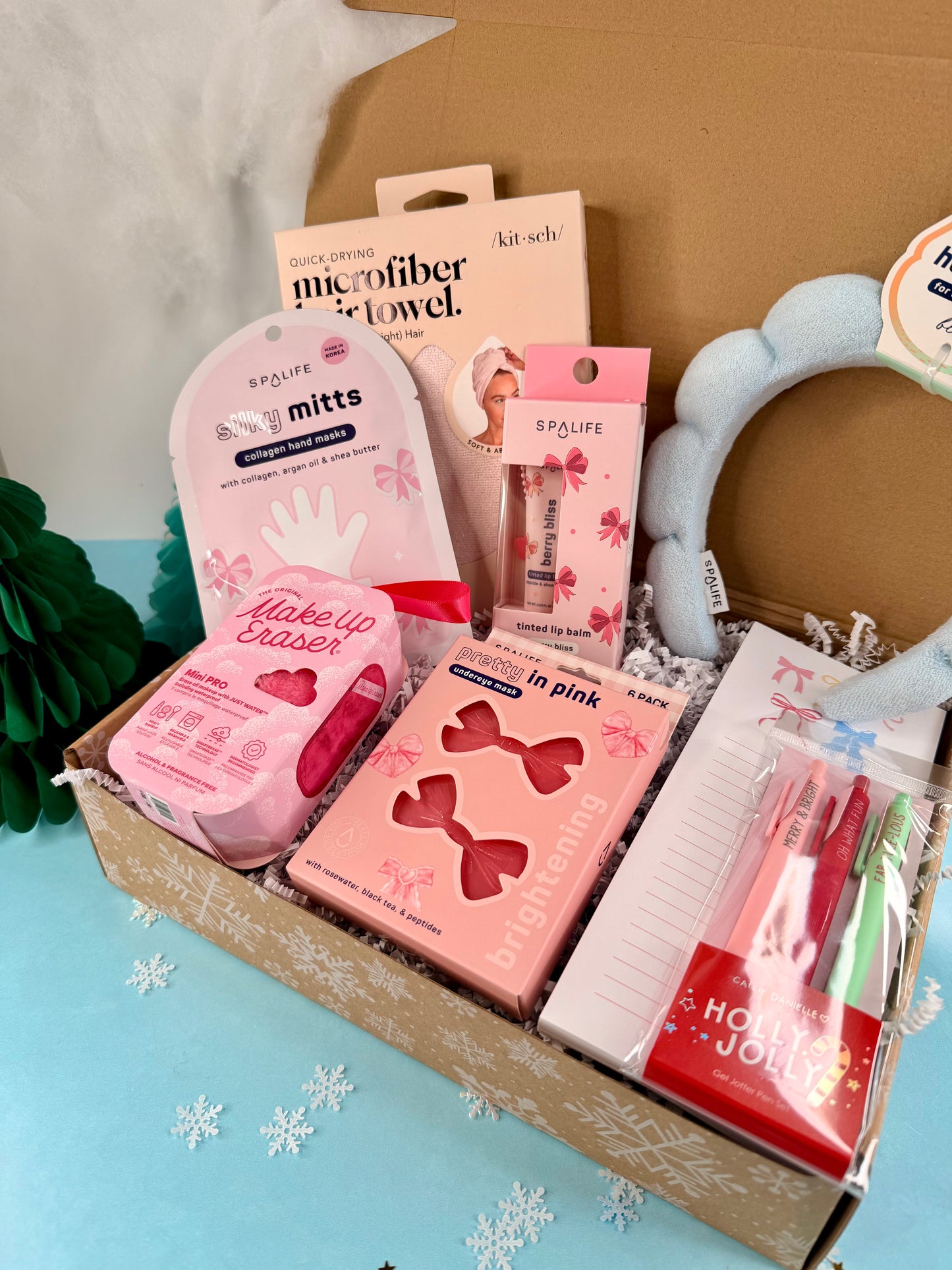 Box of beauty and self-care products with pink packaging on a light blue background