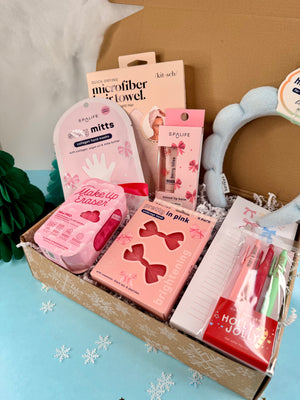 Box of beauty and self-care products with pink packaging on a light blue background