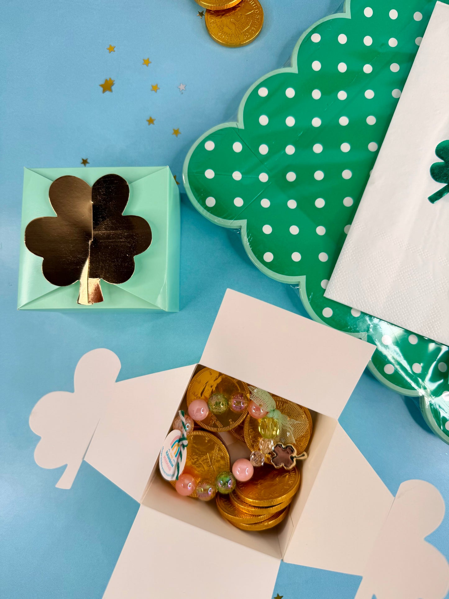 Decorative box with gold coins and a four-leaf clover on a blue background