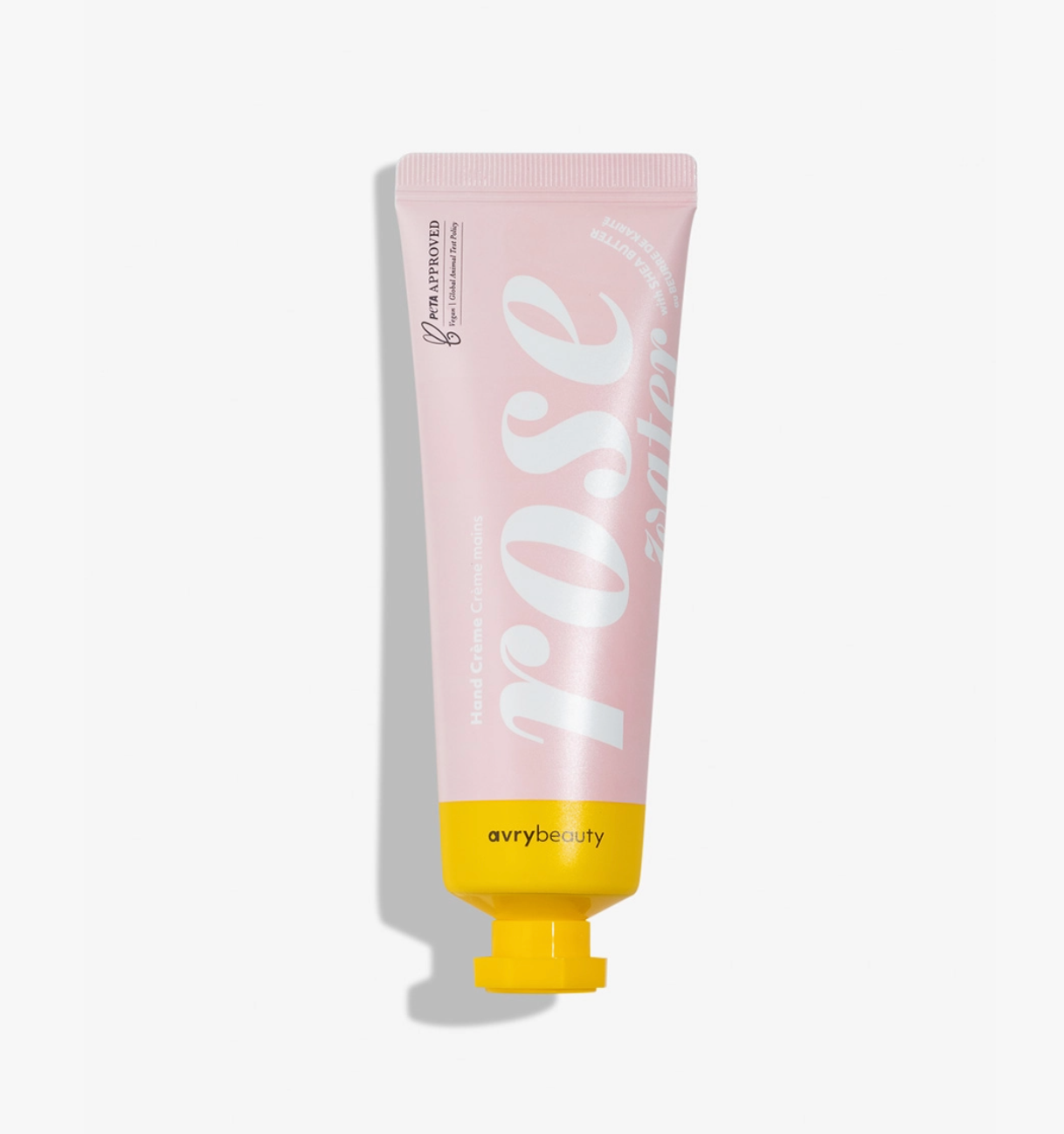 A squeeze tube of Avry Beauty Rose Water Hand Cream, featuring a light pink body with large white script lettering and a bright yellow cap, set against a clean white background with a soft shadow.