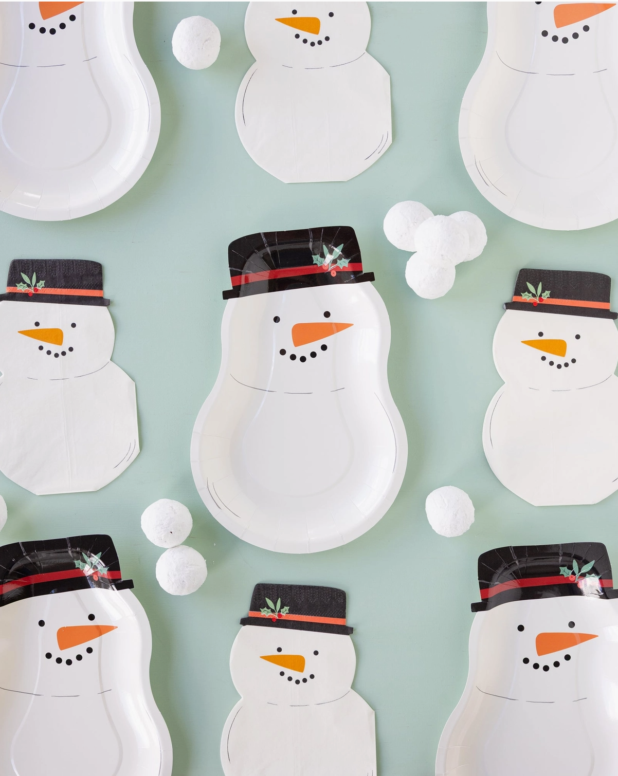 Pattern of snowman-themed paper plates and napkins on a light blue background