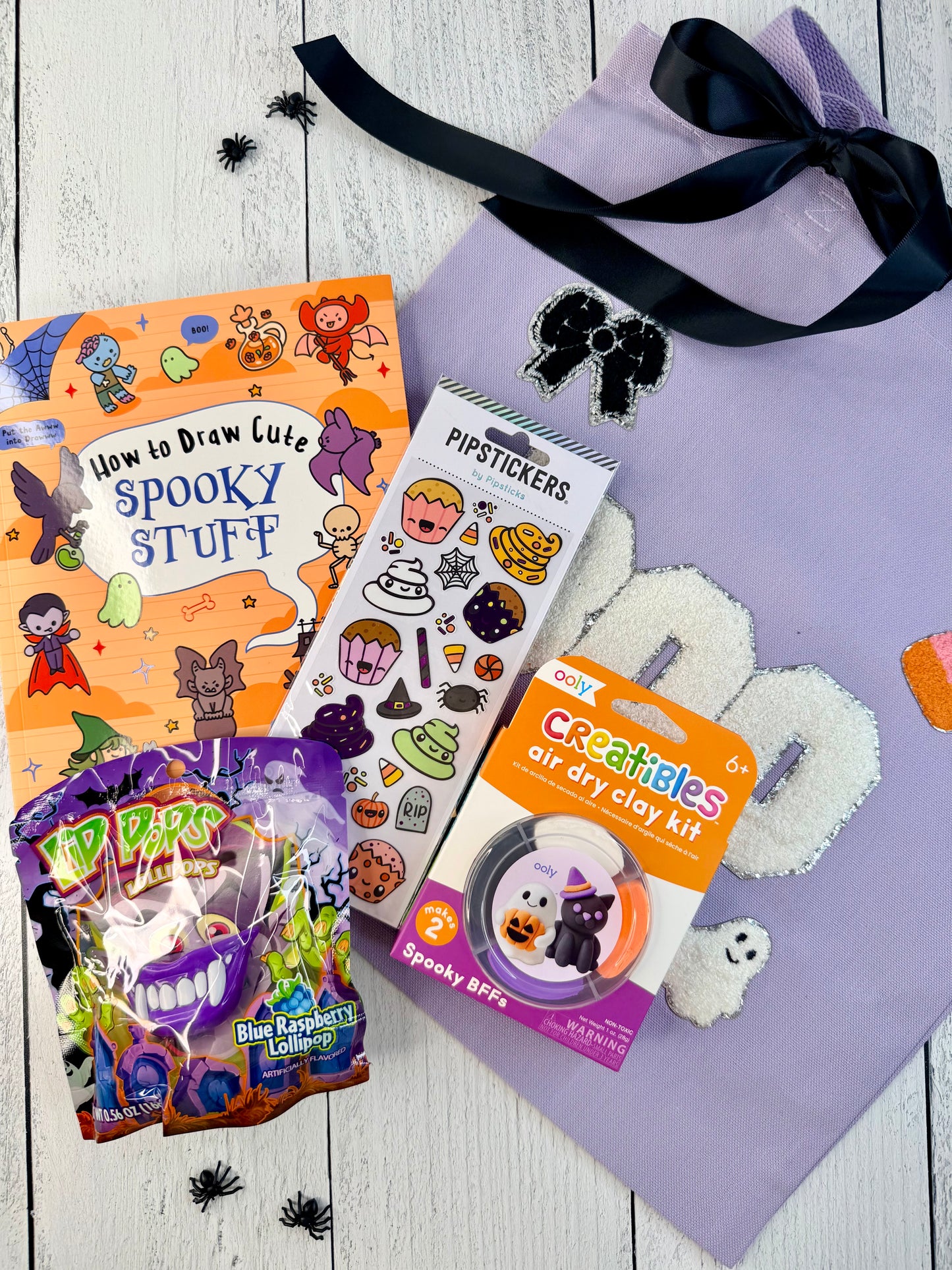 Spooky BFFs Halloween boo bag with lavender BOO tote, spooky drawing book, Pipsticks stickers, air-dry clay kit, and lollipops.