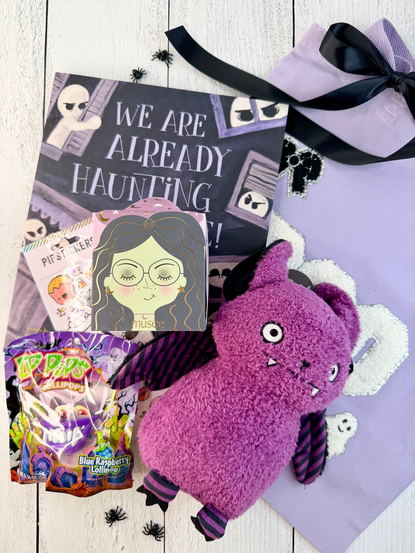
Spooky, Sweet &amp; Batty Halloween boo bag with a lavender BOO tote, purple bat plush, Halloween book, stickers, bath treat, and lollipops.