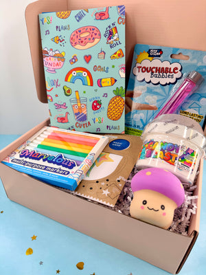 Open box containing educational and playful items including markers, books, and a plush toy on a light blue background.