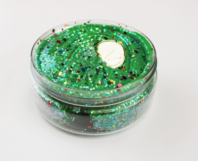 Green glittery jar with a coin on a white background