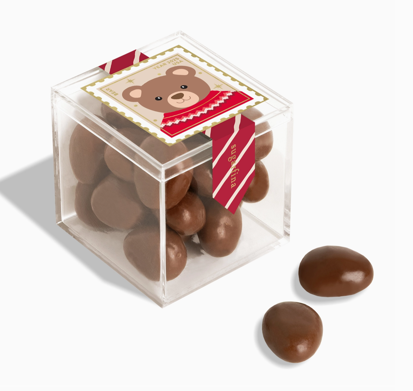 Clear cube box with chocolate candies and a bear-themed label on a white background