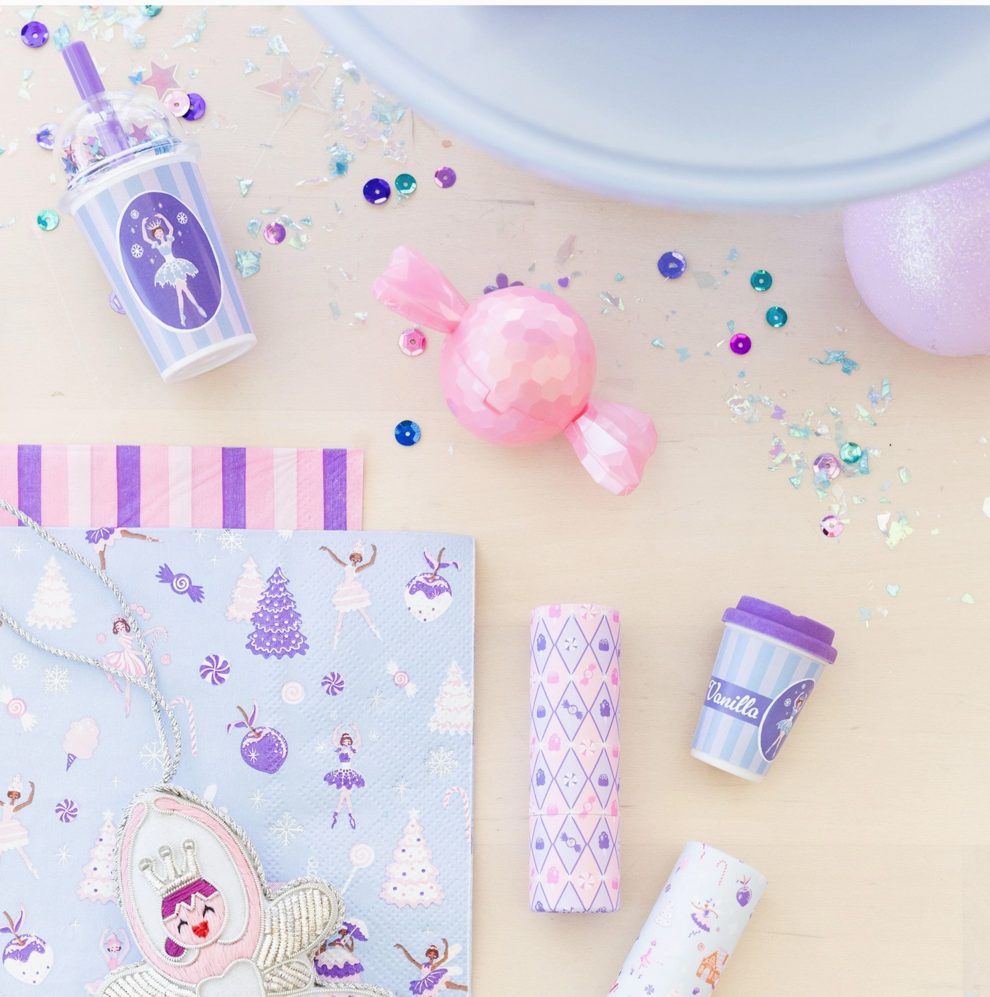 Set of pastel-colored stationery items including a notebook, pen, and cup on a light background with decorative elements.
