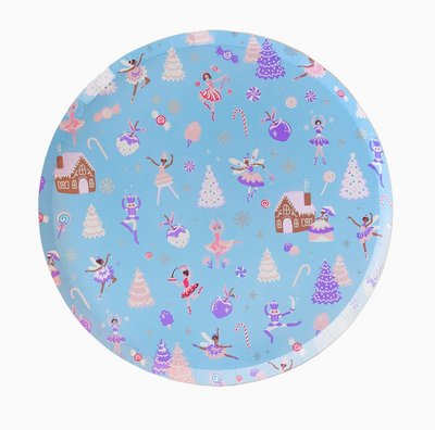 Round plate with festive design featuring ballerinas, trees, and gingerbread houses on a blue background.