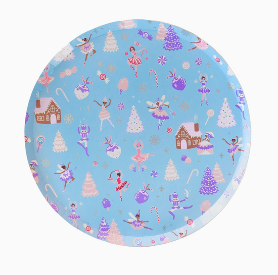 Round plate with festive design featuring ballerinas, trees, and gingerbread houses on a blue background.
