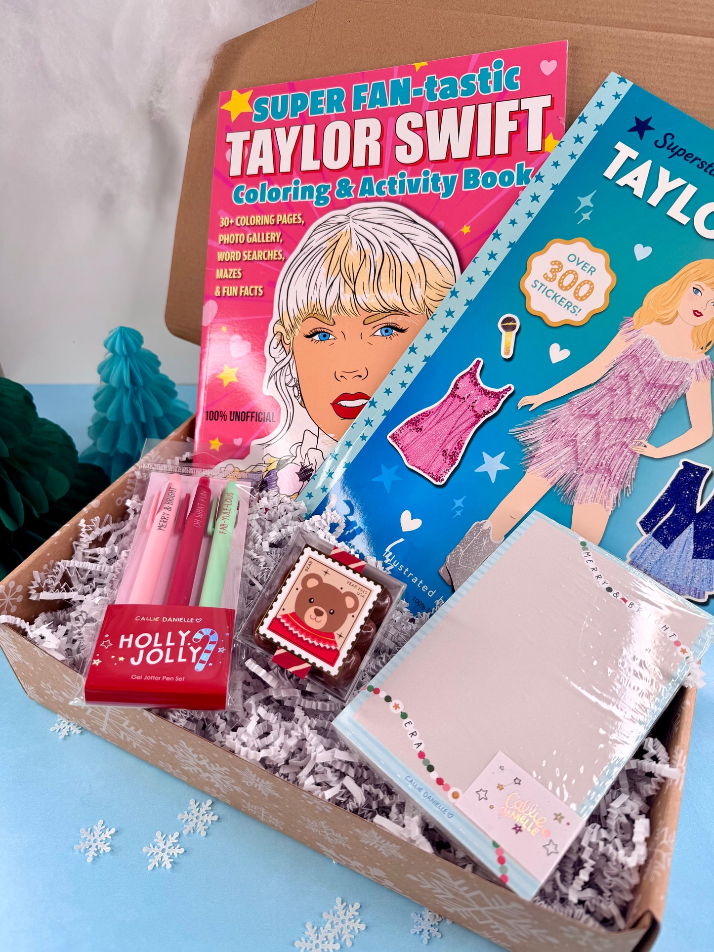 Coloring book and stationery items featuring Taylor Swift on a tray with a blue background.