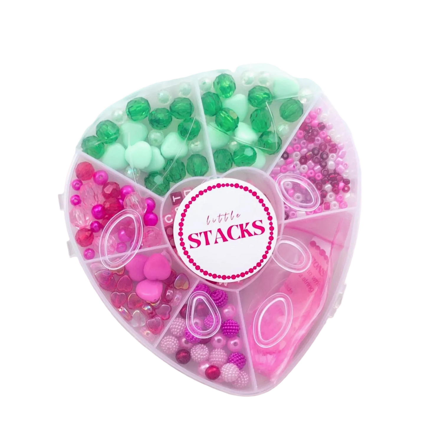 Heart-shaped container with colorful beads and 'Little Stacks' branding on a marble background