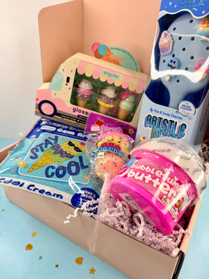 Colorful children's toys and items in a box, including a bubble gum toy and a lollipop.