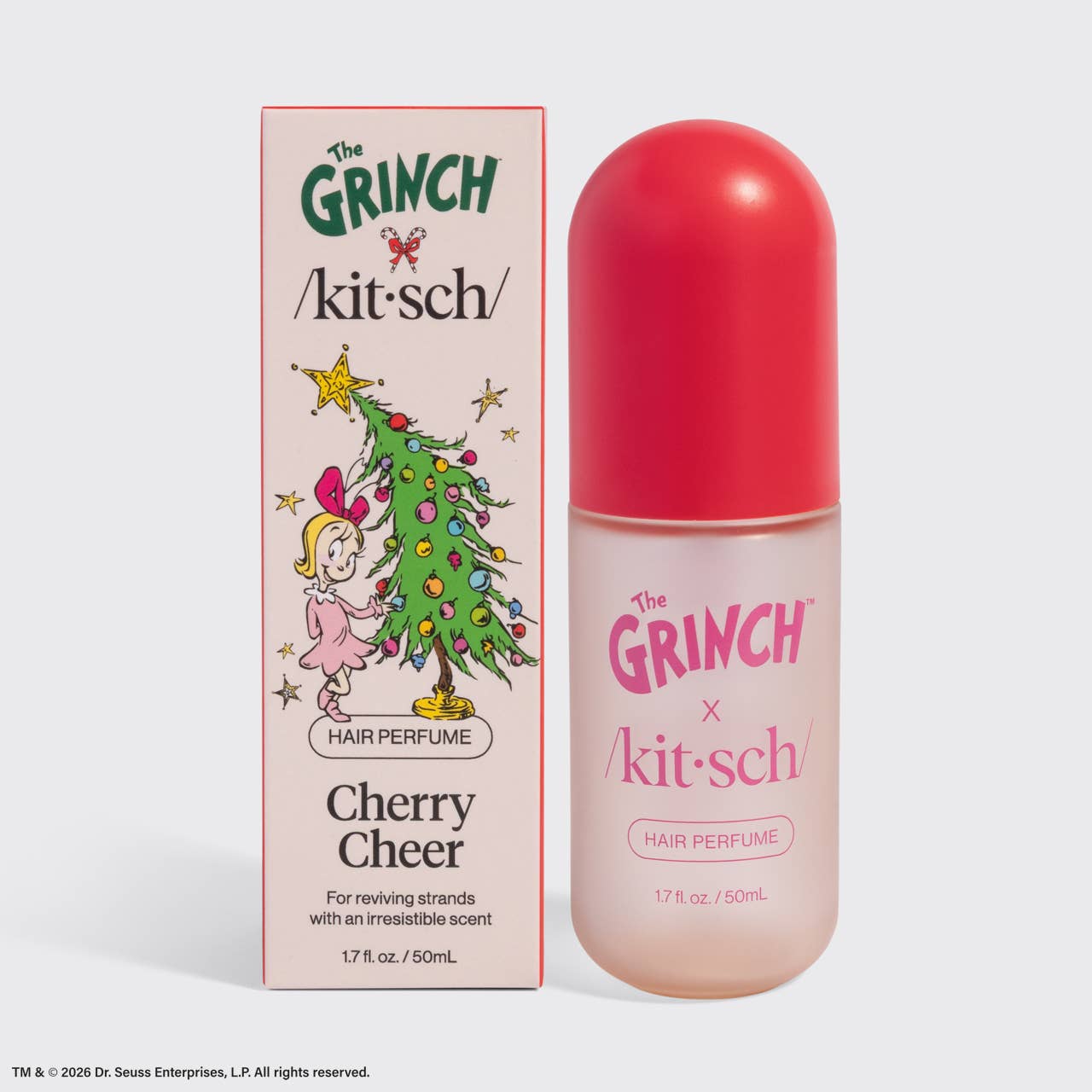 The Grinch x kit-sch Cherry Cheer hair perfume set, featuring a pink and white illustrated box next to a clear bottle with a bright red cap, on a light gray background.