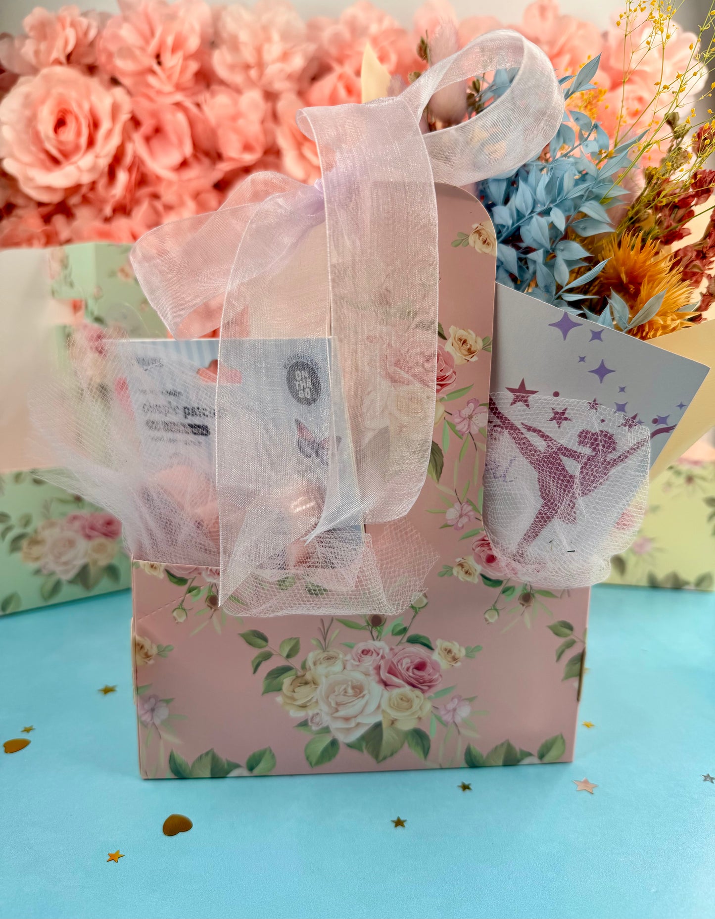 Gift bag with floral design and ribbons on a blue background