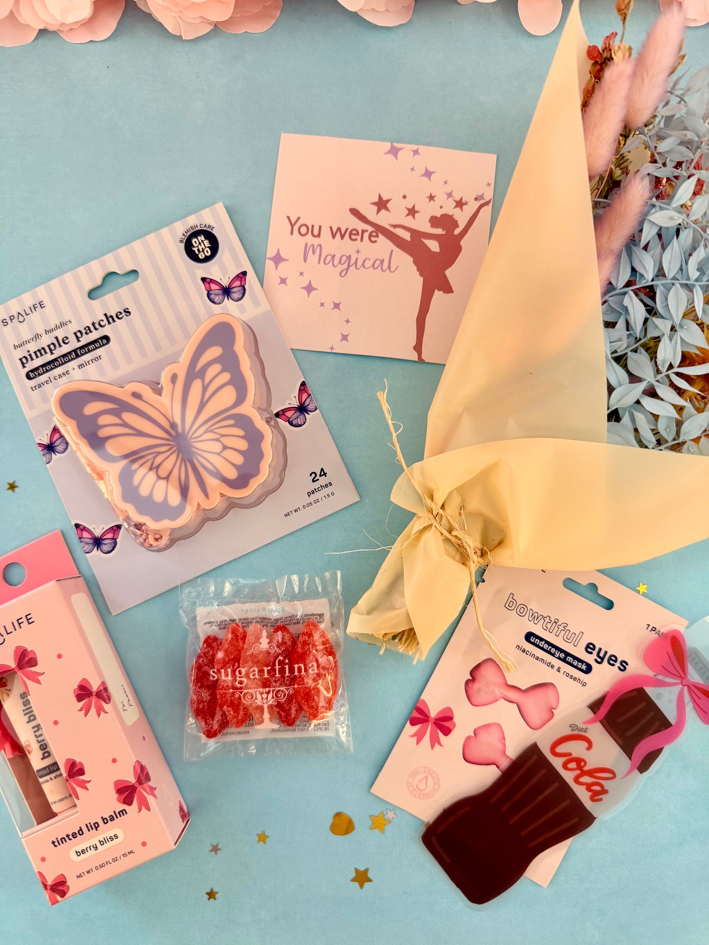 Assorted small products including a butterfly patch, lip balm, and candy on a light blue background.