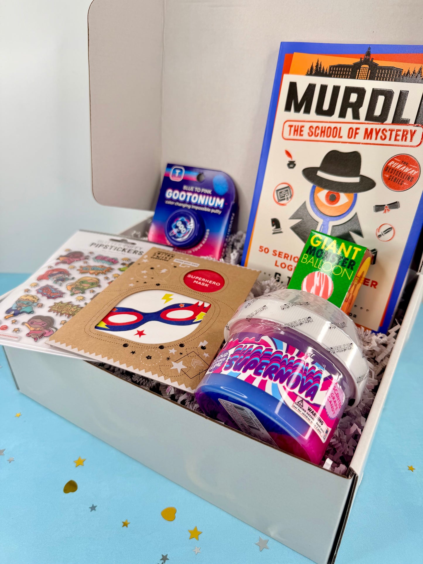Open box containing educational toys and books on a light blue background