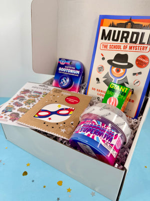 Open box containing educational toys and books on a light blue background