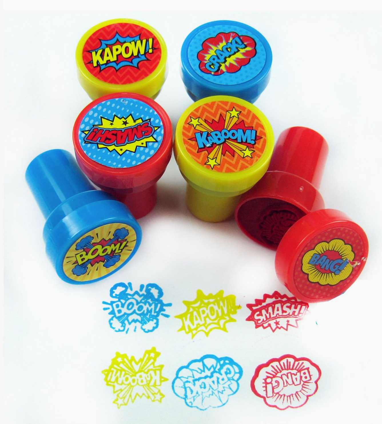 Six colorful comic-style stamp handles in red, yellow, and blue are arranged on a white background, with several sample comic bubble stamps pressed below to show the printed designs.