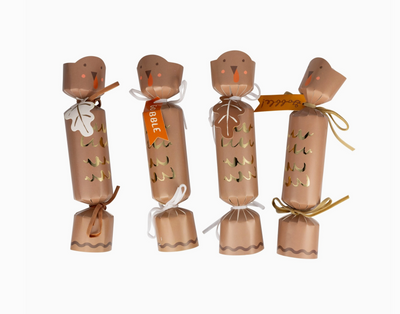 Four brown paper cracker decorations with festive designs on a white background