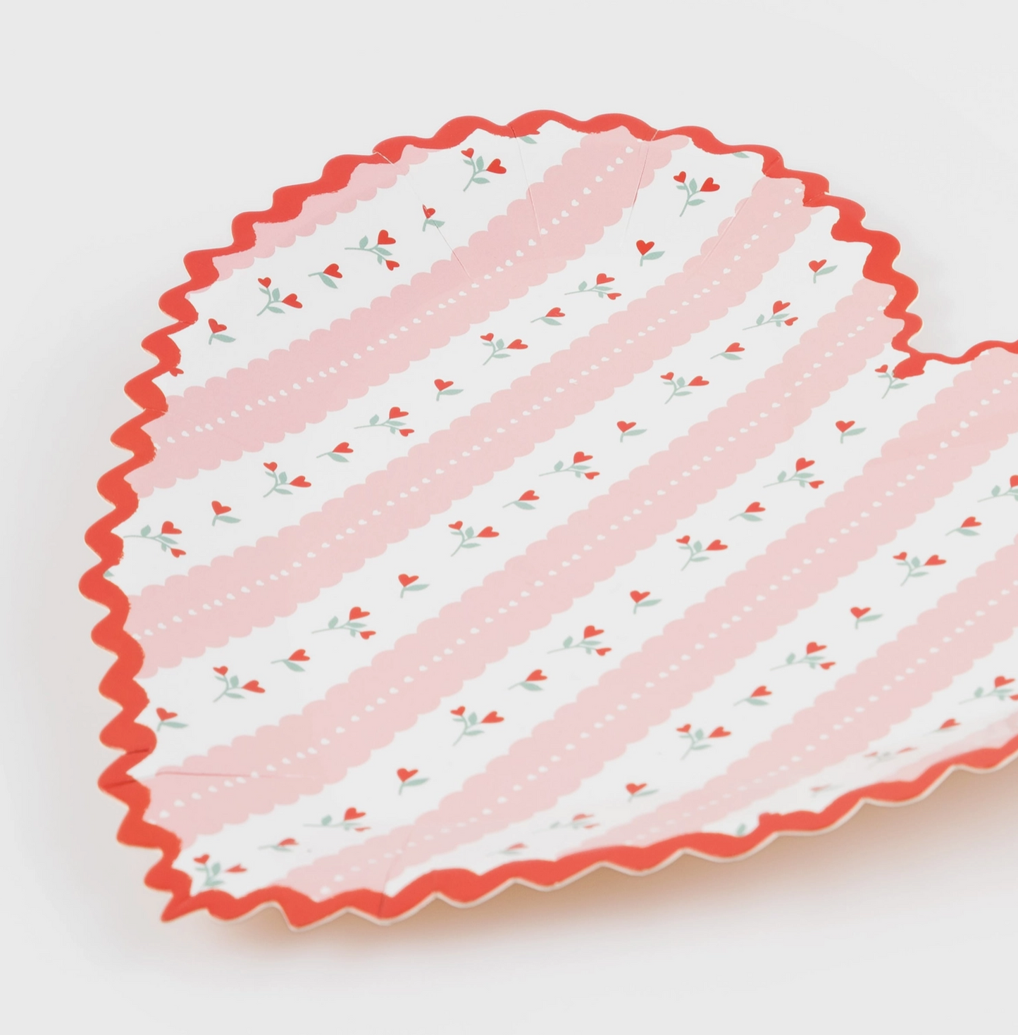 Decorative plate with pink and white striped pattern on a white background