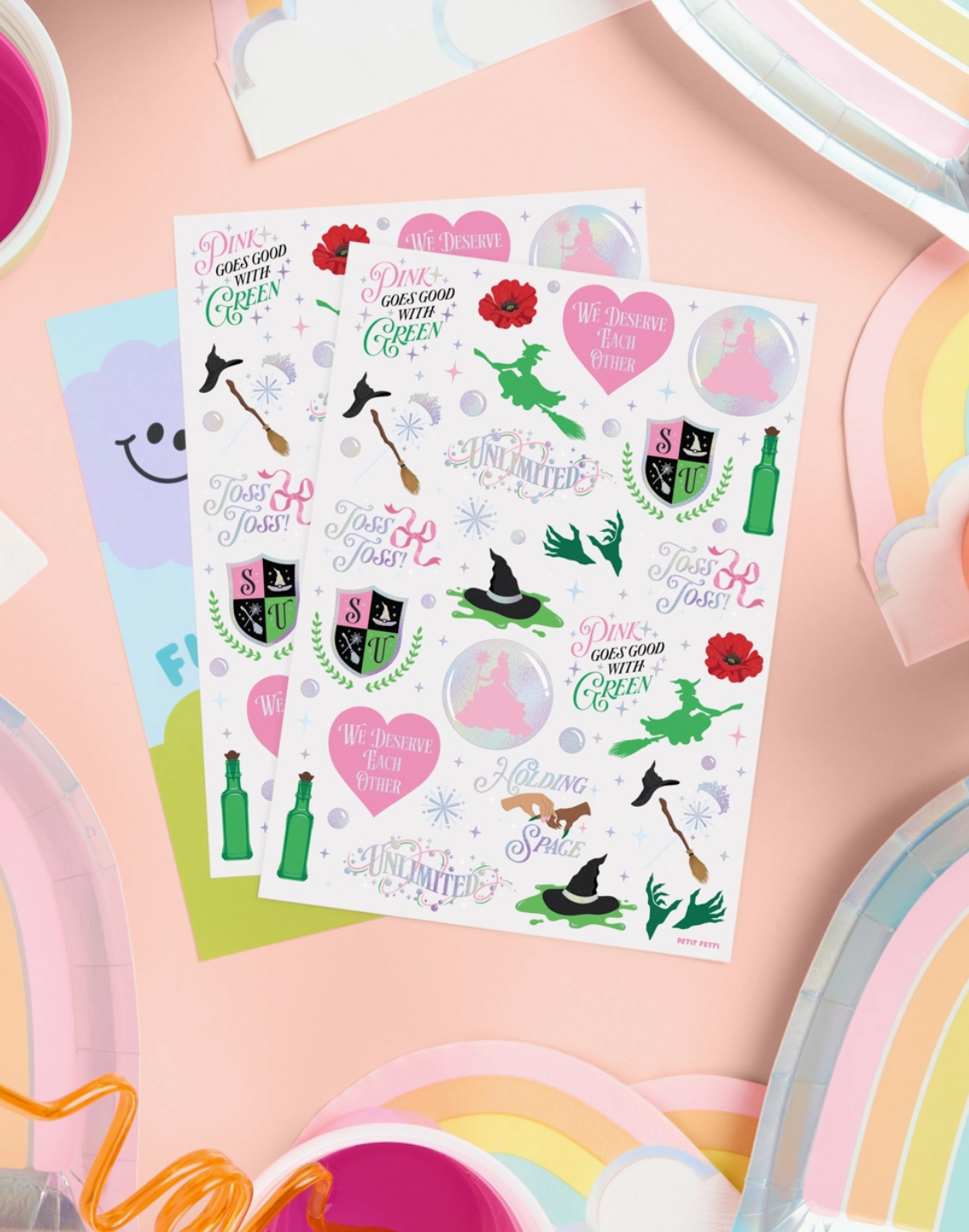 Sheet of colorful stickers with various designs on a pink surface.