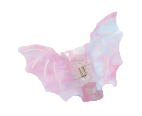Pastel-colored butterfly wings with a small charm on a light pink background