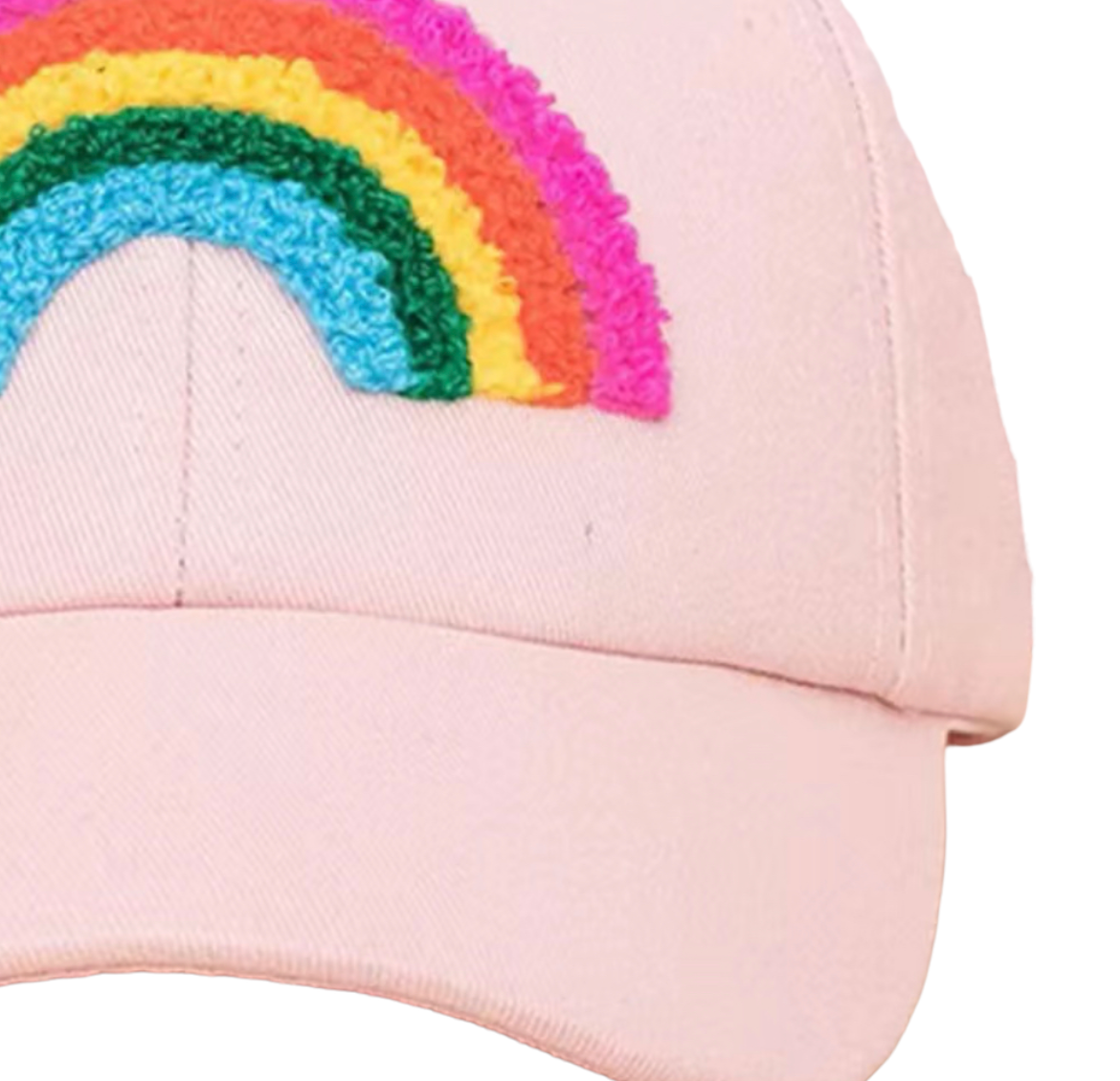 A close-up of a light pink baseball cap featuring a colorful embroidered rainbow patch on the front panel.