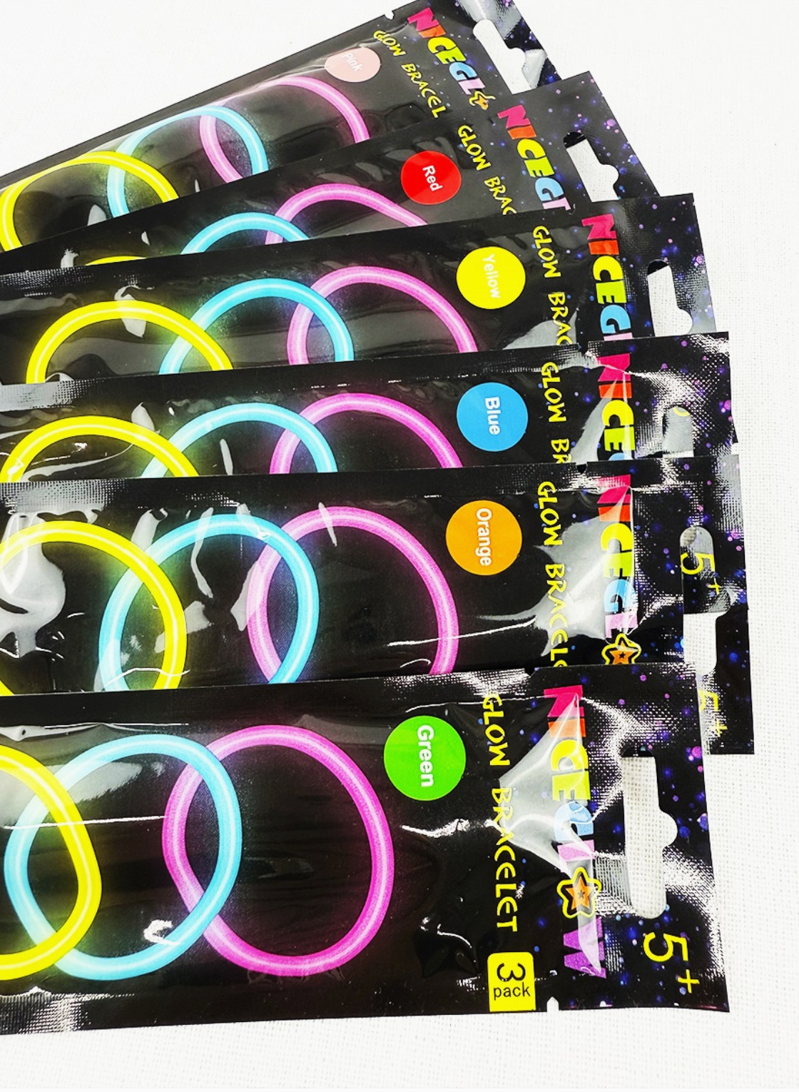 Packets of glow bracelets with colorful bands on a white background