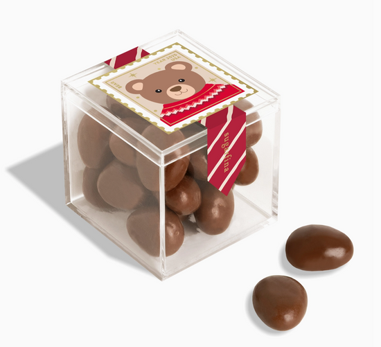 Clear cube box filled with chocolate candies featuring a bear design on a white background