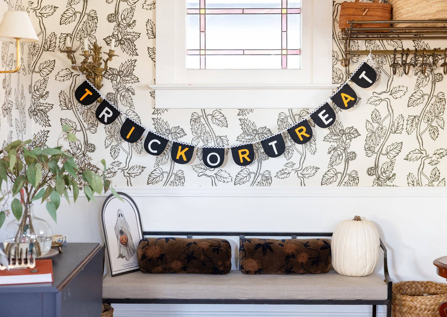 Halloween-themed room with 'Trick or Treat' banner, pumpkins, and decorative pillows.