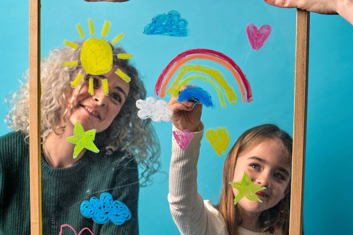Two people with colorful paper crafts on a blue background