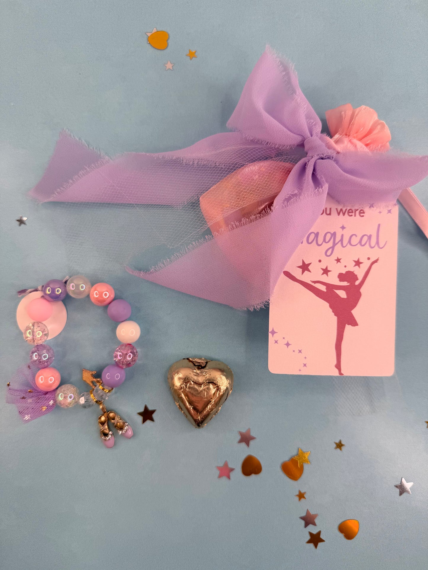 Decorative items including a bracelet, heart-shaped object, and a 'You were magical' card on a light blue background.
