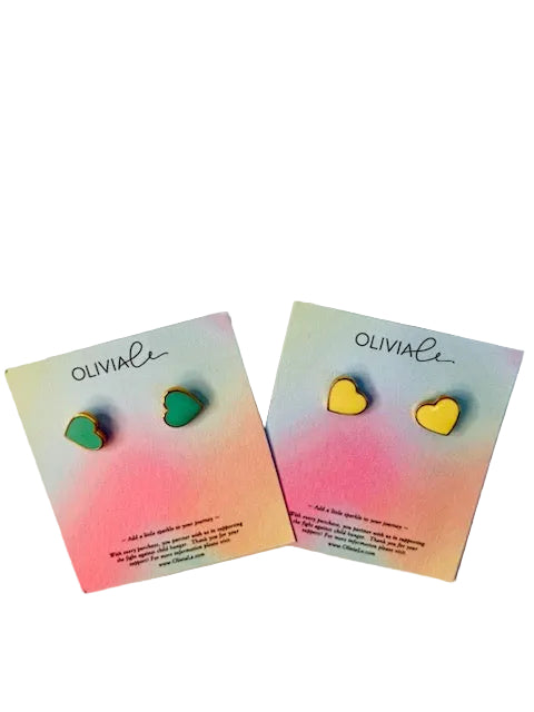 Two pairs of heart-shaped earrings on Olivia Li branded cards with a gradient background.